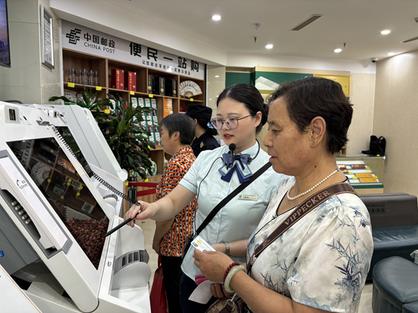 在重庆市潼南区中国邮政储蓄银行巴渝大道营业所，银行工作人员辅导市民通过ITM机自助完成城乡居民养老保险缴费。重庆市税务局供图